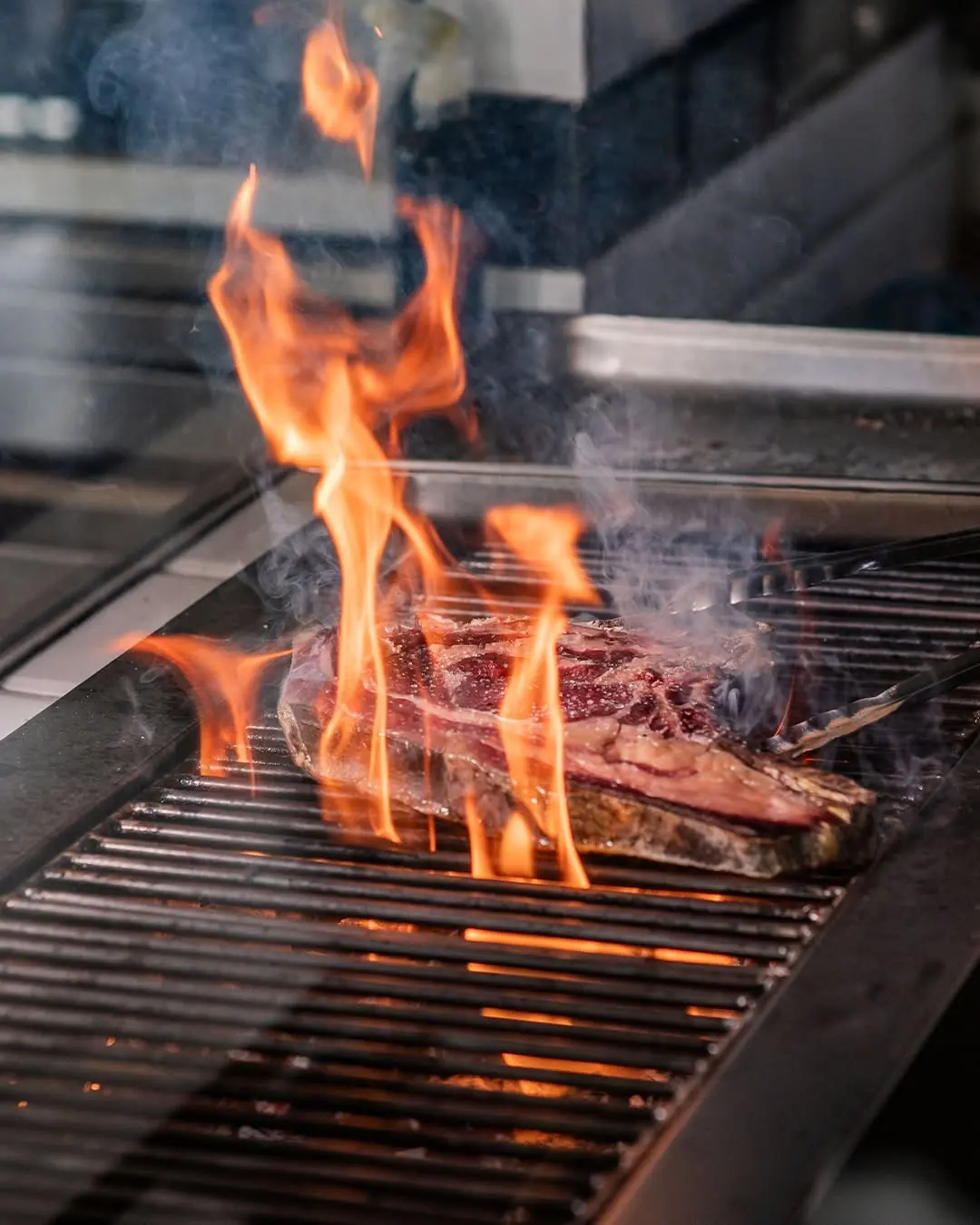 Carne haciéndose sobre la brasa de carbón vegetal en Carbón Carbón